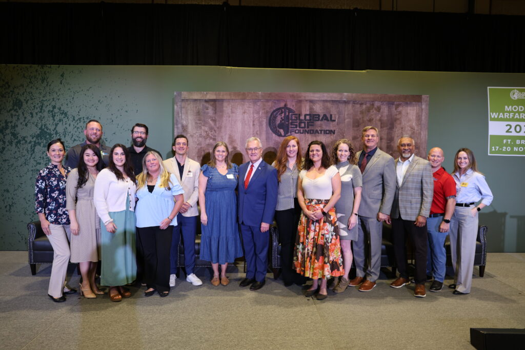 Diverse group of professionals and leaders gathered on stage at a Global Sof Foundation conference focused on modern warfare strategies in Fort Bragg, North Carolina, held from November 17-20.