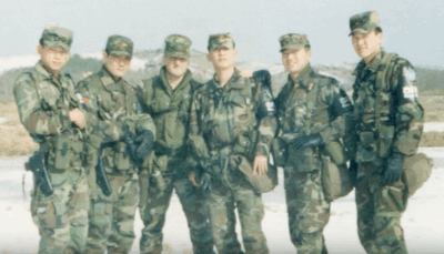 Young soldiers in camouflage military uniforms standing outdoors during winter training.